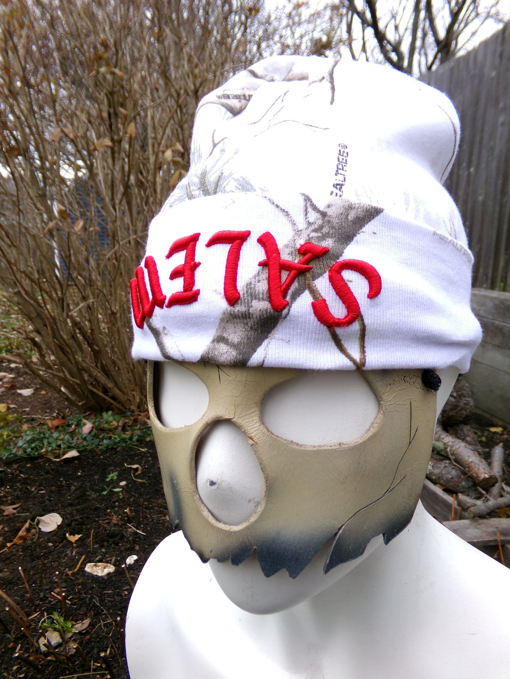 Mask with 'Salem' text on a white cloth against a natural background