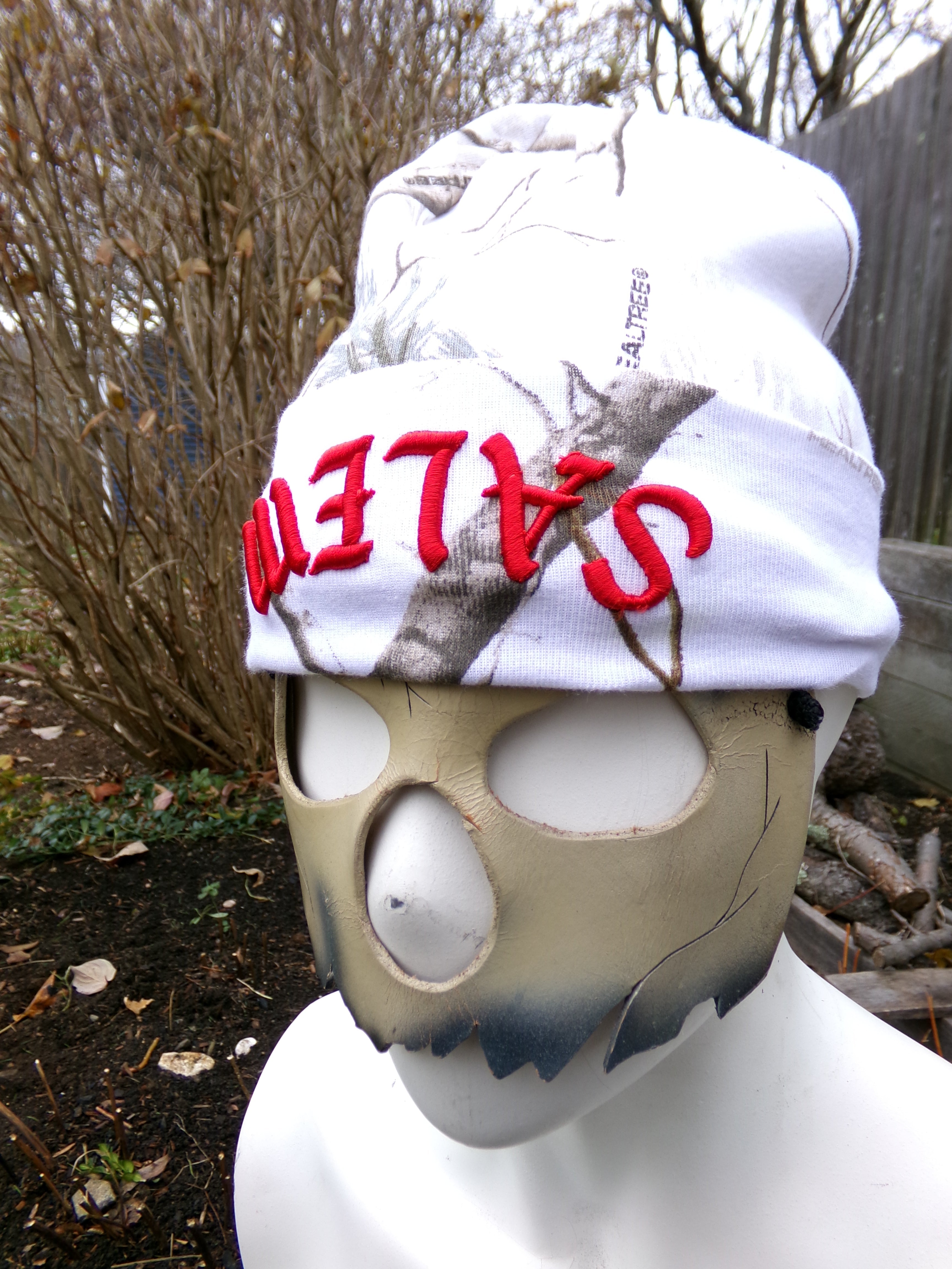 Mask with 'Salem' text on a white cloth against a natural background