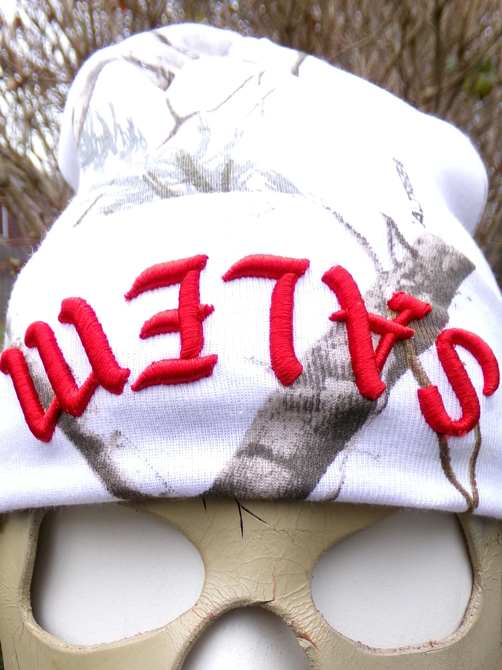 Person wearing a mask with a 'SALEM' hat outdoors