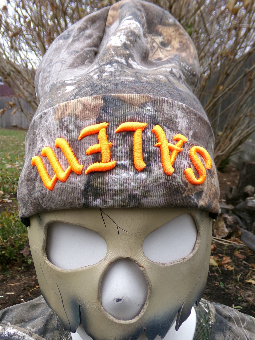 Camo-patterned mask with 'Salem' text on a natural background